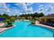 Large community pool with poolside lounge seating, cabanas, and lush tropical landscaping for a relaxing resort-like experience at 1716 Wild Indigo Ter, Oviedo, FL 32766