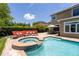 Gorgeous backyard with a pool, integrated jacuzzi, outdoor lounge seating, dining, and manicured hedges for maximum privacy at 1716 Wild Indigo Ter, Oviedo, FL 32766