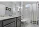 Bathroom view with light gray cabinets, white countertop, and a shower with white tile and a window at 17200 Gathering Place Cir, Clermont, FL 34711