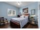 Cozy bedroom with a wooden framed bed, hardwood flooring, and a window for natural light at 17200 Gathering Place Cir, Clermont, FL 34711