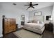 Relaxing bedroom with wood floors, ceiling fan, upholstered headboard and an ensuite bathroom at 17200 Gathering Place Cir, Clermont, FL 34711
