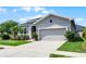 Attractive one-story home featuring manicured landscaping, and a two-car garage at 17200 Gathering Place Cir, Clermont, FL 34711