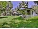Expansive backyard showcasing the home's architecture and outdoor living spaces surrounded by trees and vibrant green grass at 183 Parsons Rd, Longwood, FL 32779