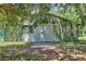 Exterior of barn covered in ivy, featuring large doors and a concrete pad, shaded by trees at 183 Parsons Rd, Longwood, FL 32779