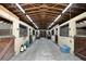 Inside barn featuring horse stalls, wooden doors and cross beams, offering a functional and well-lit space at 183 Parsons Rd, Longwood, FL 32779