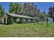 Barn exterior featuring climbing vines, fenced area, and green grass, creating a rustic and charming aesthetic at 183 Parsons Rd, Longwood, FL 32779