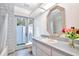 Bright bathroom features a large mirror, light wood floors, and a glass door leading to the outdoors at 183 Parsons Rd, Longwood, FL 32779