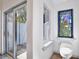 Bright bathroom featuring stained glass window, white toilet, and sliding glass door to private outdoor shower at 183 Parsons Rd, Longwood, FL 32779