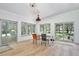 Bright dining room with wood floors, statement lighting, and multiple windows overlooking the backyard at 183 Parsons Rd, Longwood, FL 32779