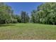 Expansive green lot surrounded by mature trees with a fenced area in the distance at 183 Parsons Rd, Longwood, FL 32779