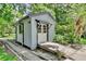 Charming outbuilding featuring a quaint design, a wooden ramp, and surrounded by lush greenery and landscaping at 183 Parsons Rd, Longwood, FL 32779