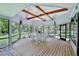 Enclosed screened porch with a round table, seating, wooden floors, and a ceiling fan at 183 Parsons Rd, Longwood, FL 32779
