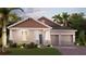 Charming one-story home featuring a two-car garage, manicured lawn, and welcoming front entrance at 1869 Clear Sky Dr, Kissimmee, FL 34744