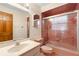 Retro bathroom featuring a pink tile shower, toilet, and large mirror at 2018 N Normandy Blvd, Deltona, FL 32725