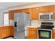 A kitchen featuring stainless steel appliances, wooden cabinets, and tile flooring at 2018 N Normandy Blvd, Deltona, FL 32725