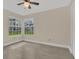 Bright bedroom featuring two windows, ceiling fan, and tile flooring at 2040 Royal Bay Blvd # 31, Kissimmee, FL 34746
