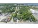 This aerial view showcases a charming home nestled among lush greenery and mature trees, with a glimpse of the water in the distance at 2418 W 1St St, Sanford, FL 32771