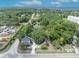 This aerial view showcases a charming home nestled among lush greenery and mature trees, with a glimpse of the water in the distance at 2418 W 1St St, Sanford, FL 32771