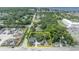 An aerial view outlines property in yellow, with lush trees surrounding the charming home on a sun-drenched lot at 2418 W 1St St, Sanford, FL 32771