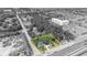 An aerial view outlines property in yellow against gray, with lush trees surrounding the charming home near waterfront community amenities at 2418 W 1St St, Sanford, FL 32771