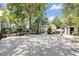 Large backyard with mature trees, gravel ground cover, and multiple storage sheds at 2418 W 1St St, Sanford, FL 32771