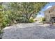 A gravel driveway leads to a lush yard with mature trees draped in Spanish moss at 2418 W 1St St, Sanford, FL 32771