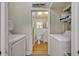 Well-organized laundry room with washer, dryer, and storage, and a peek into a powder room at 2418 W 1St St, Sanford, FL 32771
