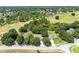 Aerial view of homes near a golf course, surrounded by mature trees at 24720 Calusa Blvd, Eustis, FL 32736