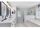 Bathroom showcasing a glass shower, soaking tub, a double vanity, and bright natural light at 24720 Calusa Blvd, Eustis, FL 32736