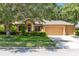 Charming single-story home boasts a three-car garage, manicured lawn, and mature trees for shade at 24720 Calusa Blvd, Eustis, FL 32736
