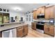 Bright kitchen with wood cabinets, granite countertops, stainless steel appliances and wood-look flooring at 24720 Calusa Blvd, Eustis, FL 32736