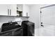Modern laundry room featuring front loading machines and white cabinets at 24720 Calusa Blvd, Eustis, FL 32736