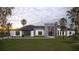 Modern single-story home featuring clean lines, stone accents and professional landscaping with palm trees at 26019 Estates Ridge Dr, Sorrento, FL 32776