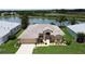 Aerial view of a lovely single-story home with a well-manicured lawn, lush landscaping, and a serene lake view at 27143 Nostalgia Dr, Leesburg, FL 34748