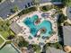 Aerial view of the Legacy of Leesburg community pool, complete with tables, chairs, and lush landscaping at 27143 Nostalgia Dr, Leesburg, FL 34748