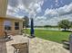 Spacious backyard features lush green lawn, patio area with seating, and stunning lake views at 27143 Nostalgia Dr, Leesburg, FL 34748