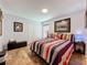Relaxing bedroom with striped quilt, framed artwork, and a cozy atmosphere at 27143 Nostalgia Dr, Leesburg, FL 34748