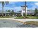 Legacy of Leesburg clubhouse featuring a clock tower, lush landscaping, and beautiful architecture at 27143 Nostalgia Dr, Leesburg, FL 34748