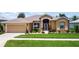 Charming single-story home featuring a well-maintained lawn, decorative landscaping, and a two-car garage at 27143 Nostalgia Dr, Leesburg, FL 34748