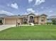 Charming home with a neatly landscaped front yard, vibrant plants, and a welcoming entrance at 27143 Nostalgia Dr, Leesburg, FL 34748