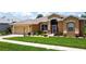 Well-manicured front yard featuring lush lawn, vibrant landscaping, and inviting curb appeal at 27143 Nostalgia Dr, Leesburg, FL 34748