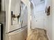 Hallway with wood floors and an arched doorway to the kitchen featuring a stainless steel refrigerator at 27143 Nostalgia Dr, Leesburg, FL 34748