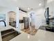 Open concept kitchen with stainless steel appliances, granite counters, white cabinets, and wood-look flooring at 27143 Nostalgia Dr, Leesburg, FL 34748