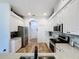 Modern kitchen featuring white cabinetry, stainless steel appliances, granite countertops, and wood-look flooring at 27143 Nostalgia Dr, Leesburg, FL 34748