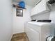 Convenient laundry room equipped with washer, dryer, overhead cabinets, and clean, white walls at 27143 Nostalgia Dr, Leesburg, FL 34748