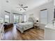 Serene main bedroom with hardwood floors, fan, and a sliding door to a private balcony at 27143 Nostalgia Dr, Leesburg, FL 34748