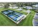 Aerial view of multiple, well-maintained pickleball courts in a vibrant, active community with manicured lawns at 27143 Nostalgia Dr, Leesburg, FL 34748