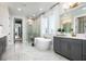 Modern bathroom featuring a freestanding tub, walk-in shower, dual vanities, and neutral marble-look tile flooring at 2739 Ravencliffe Ter, Oviedo, FL 32765