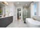 Elegant bathroom featuring a soaking tub, glass-enclosed shower, marble floors, and a double vanity at 2739 Ravencliffe Ter, Oviedo, FL 32765