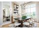 Bright dining room with large mirror, modern chandelier, and dining table with white chairs and black legs at 2739 Ravencliffe Ter, Oviedo, FL 32765